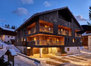 a large wooden building with a lot of windows at Residence Villa Al Sole in Corvara in Badia