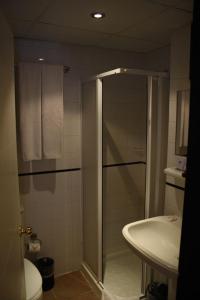 a bathroom with a shower and a toilet and a sink at Albano Hotel in Çeşme