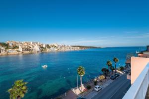 una vista de un cuerpo de agua con una ciudad en Blue Harbour Seafront Penthouse with large terrace with panoramic sea views - by Getawaysmalta, en St Paul's Bay