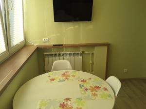 LBE apartments في نارفا: طاولة وكراسي في غرفة مع تلفزيون