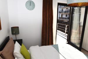 a room with a bed and a window with a clock at MonikaRooms in Zagreb
