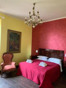 a bedroom with a large red bed with a chandelier at Amico Hotel in Rome