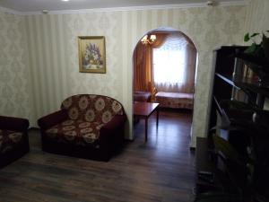 a living room with a chair and a window at Hotel Gloria in Cherepovets