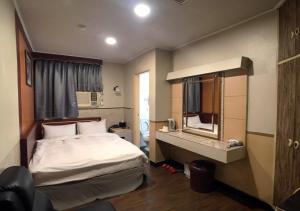 a hotel room with a bed and a mirror at Huang Kai Hotel in Taichung