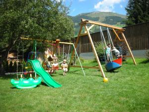 a group of children playing on swings in a yard at Pension Theresia in Dorfgastein