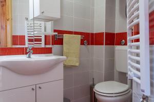 a bathroom with a white toilet and a sink at Apartments In in Jahorina +36 photos