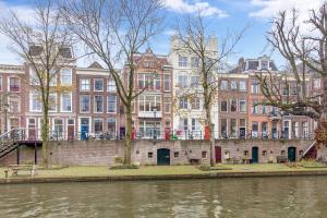 een rij hoge gebouwen naast een rivier bij De Verrassing aan de Werf in Utrecht