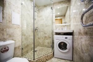 a bathroom with a washing machine and a shower at Aparthotel Capital Aparton in Minsk