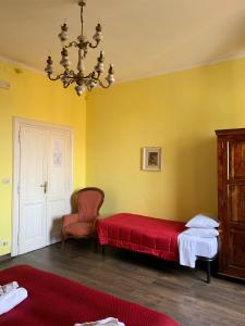 ローマにあるアミコ ホテルのベッドルーム1室(ベッド1台、椅子、シャンデリア付)
