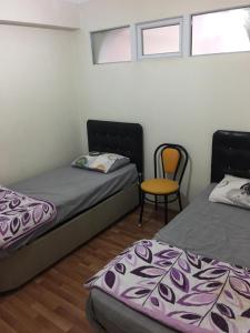 ブルサにあるAbbasi Apart-4のベッド2台、椅子、窓が備わる客室です。