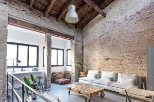 a living room with a white couch and a brick wall at Loft by the Beach in Valencia