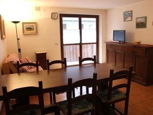 ein Esszimmer mit einem Holztisch und Stühlen in der Unterkunft Appartamento di Viola & Elia in Predazzo