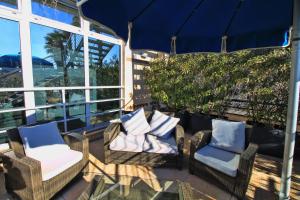 a patio with wicker chairs and pillows at Hotel San Terenzo in Lerici