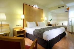 um quarto de hotel com uma cama grande e um sofá em Eurostars Centrum Alicante em Alicante