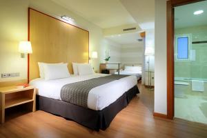 um quarto de hotel com uma cama grande e uma casa de banho em Eurostars Centrum Alicante em Alicante