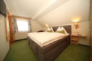 um quarto com uma cama grande e uma janela em Aignerhof em Haus im Ennstal