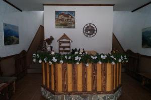 una recinzione di legno con fiori e un orologio su un muro di Dacha a Yasinia
