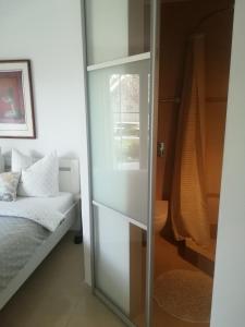 a bedroom with a bed and a glass closet at Angel's Nest Apartment in Komenda