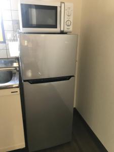 a microwave on top of a refrigerator in a kitchen at 201Keiko's Home 大空間2LDKロフト付きfree parking in Kasugabaru