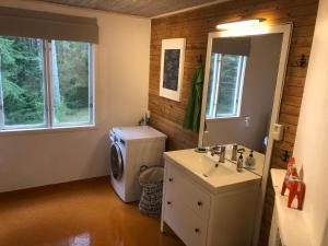 a bathroom with a sink and a washing machine at Ferienhaus Småland in Fågelfors