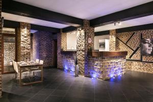 uma sala de jantar com paredes de tijolos e uma mesa em Appart-Hotel Léopold Liège Centre em Liège