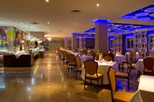 a restaurant with white tables and chairs and a bar at Elba Motril Beach & Business Hotel in Motril