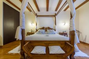 a bedroom with a wooden canopy bed with white pillows at Hotel Tossal d'Altea in Altea