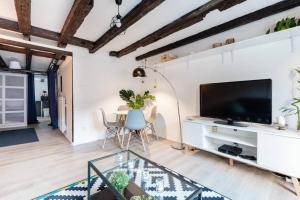 a living room with a large television and a table at Central & Cosy Apartment Strasbourg City Center in Strasbourg