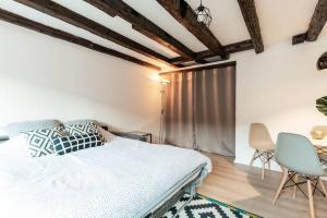 a bedroom with a bed and a table and chairs at Central & Cosy Apartment Strasbourg City Center in Strasbourg