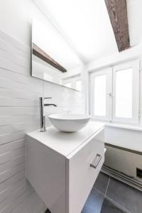 a white bathroom with a sink and two windows at Central & Cosy Apartment Strasbourg City Center in Strasbourg +17 photos