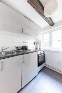 ストラスブールにあるCentral & Cosy Apartment Strasbourg City Centerの白いキッチン(白いキャビネット、シンク付)