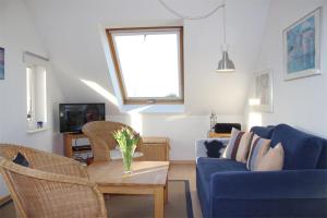 キュールングスボルンにあるFewo-Perner Meerblickのリビングルーム(青いソファ、テーブル付)