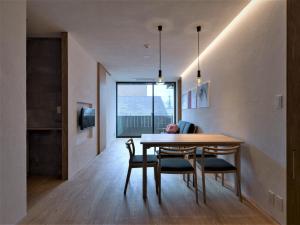 a dining room with a table and chairs and a window at Komatsu Residences in Kyoto