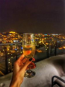 a person holding up a glass of wine at night at 5 Star Residence in Braşov