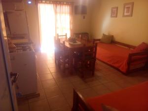 a room with two beds and a table and a kitchen at Apartamento Confortable Samai Huasi in Las Grutas +11 photos