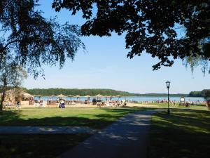 a park with a beach with umbrellas and people at Ferienhaus SUN Schein in Templin in Templin