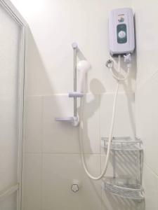 a shower with a white hose attached to a wall at MoonViews Apartment in Panglao