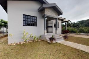 a white house with black windows and grass at EJAB Belama Phase 3 in White Hill