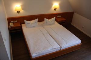 En eller flere senge i et værelse på Landhotel Rügen