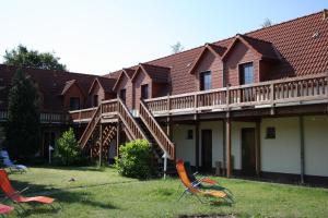 eine Reihe von Häusern mit Terrassen und Stühlen im Hof in der Unterkunft Landhotel Rügen in Stönkvitz