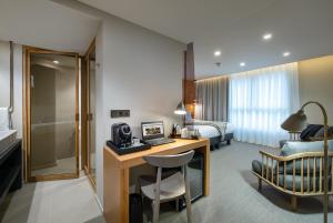 a hotel room with a desk and a bedroom at 9Hotel Paquis in Geneva