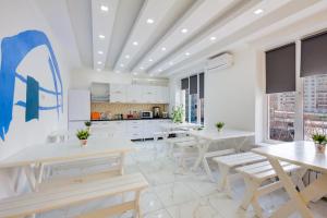 une cuisine blanche avec des tables et des bancs blancs dans l'établissement WHITE HOTEL & HOSTEL, à Bishkek