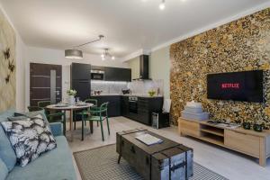 a living room with a couch and a tv and a kitchen at Prague Luxury Apartments Parking by Michal&Friends in Prague