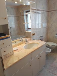 a bathroom with a sink and a tub and a toilet at Apartments Gana in La Villa