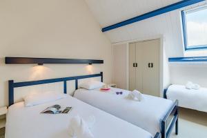 1 dormitorio con 2 camas y ventana en Azureva Kerjouanno en Arzon