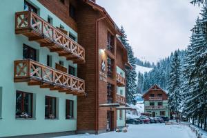 a hotel building with snow on the ground at Hotel Jasná in Demanovska Dolina