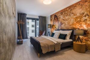 a bedroom with a bed and a wall with a painting at Prague Luxury Apartments Parking by Michal&Friends in Prague
