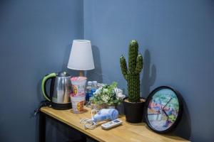 a table with a lamp a cactus and a mirror at Phố Đá Hotel in Lagi