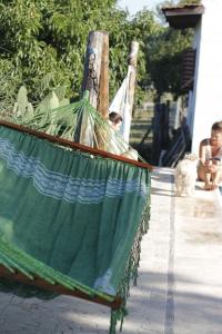 a green hammock with two children sitting on a porch at Las Gemelas in Bialet Massé