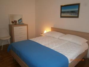um quarto com uma cama azul e branca e uma cómoda em Apartments Sea and Sun em Rabac